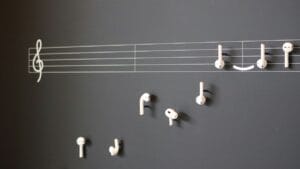Escritorio de un músico con varias partituras que ilustran las diferencias entre una transcripción, un arreglo y una adaptación musical.