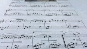 Ilustración conceptual que muestra cómo la teoría musical, con sus escalas y acordes, es la base para entender la composición de una partitura.